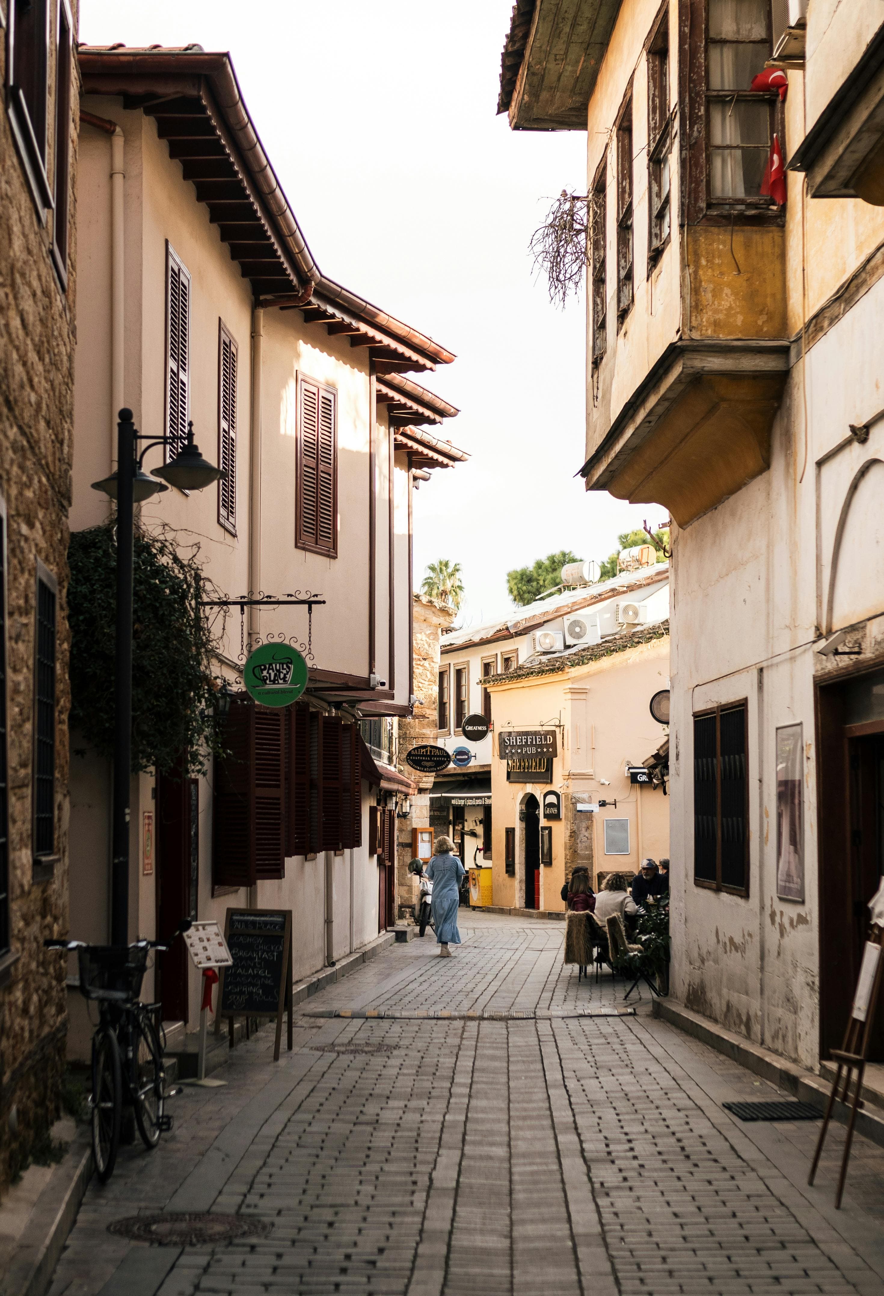 Narrow cobblestone street in Merkez, Turkey, lined with historic stone buildings and wooden balconies