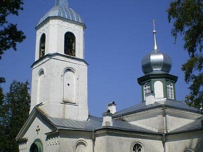 White church with a bell tower and green onion dome in Kadrina, Estonia