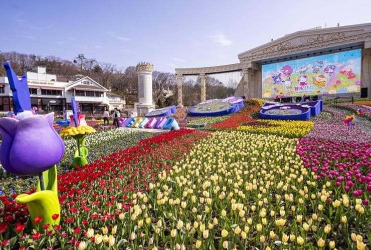 A vibrant spring-themed theme park with colorful flowers and festive decorations, capturing the joy of visiting during the spring season.