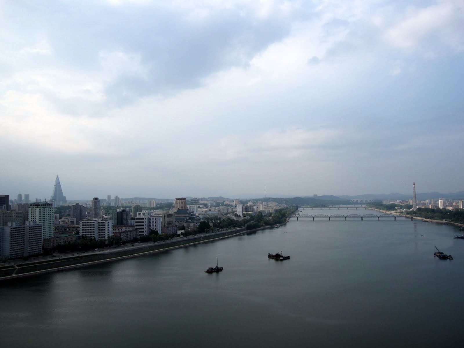 Wide cityscape of Pyongyang featuring landmarks along the river