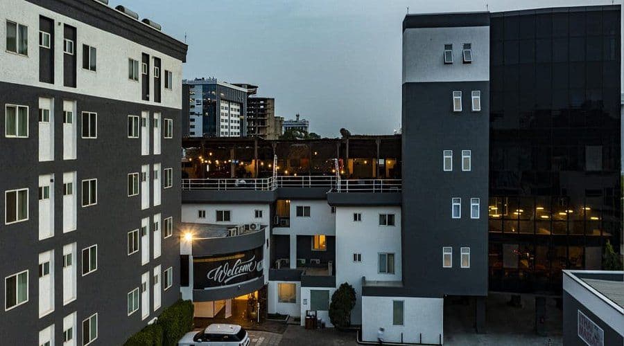 Elevated view of modern multi-story residential and commercial buildings at dusk with a distant city skyline in Greater Accra, Ghana