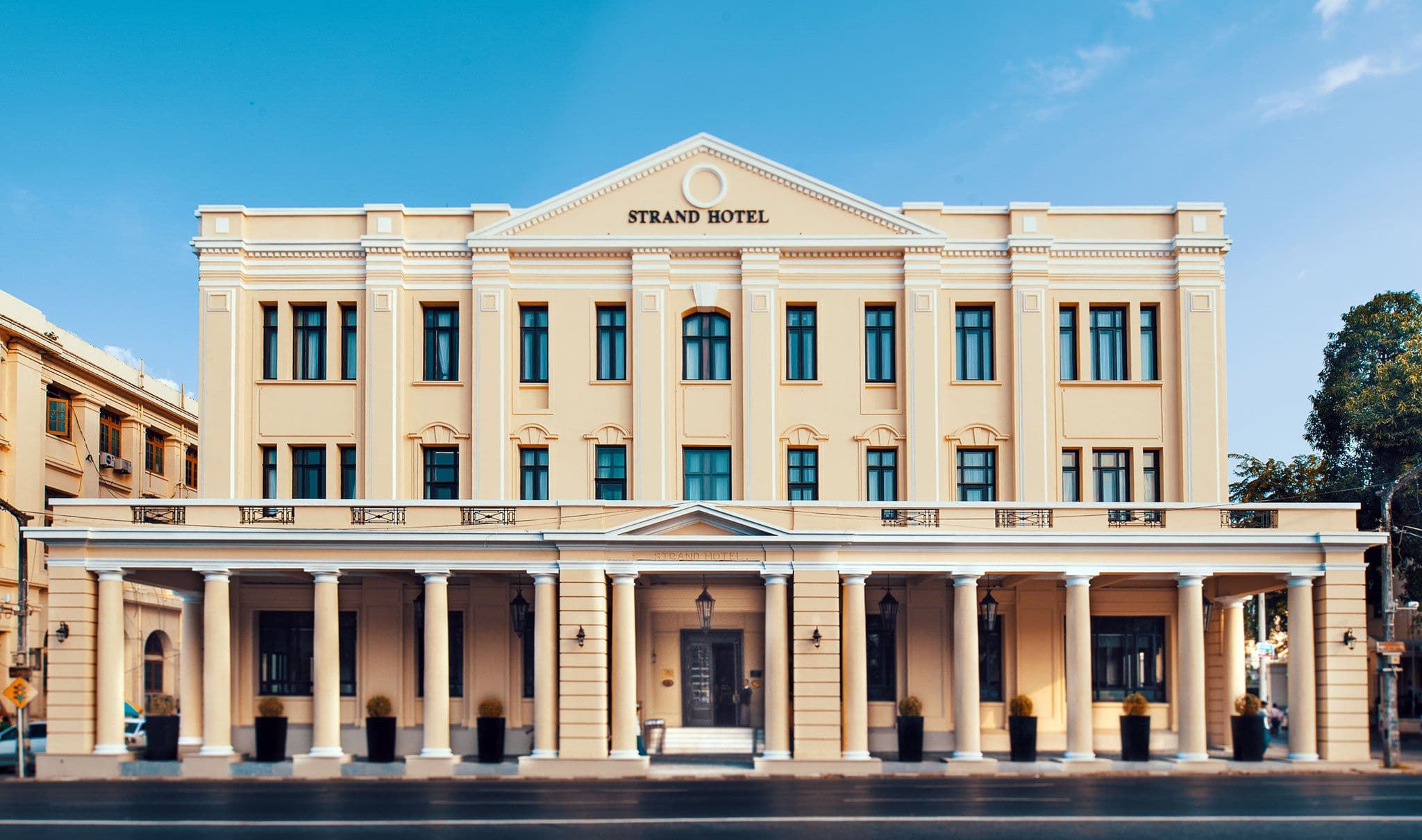Exterior facade of The Strand Hotel in Yangon, Myanmar, showcasing its Art Deco architecture