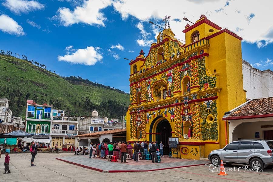 Establishing view of the main square in San Andrés Xecul, Guatemala, featuring historic architecture