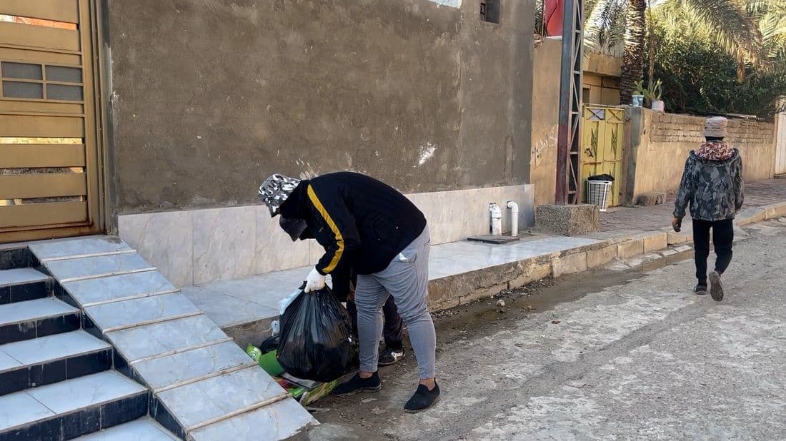 Paved street in Al ‘Amārah beside a building, showing the everyday urban fabric where local markets and kitchens operate.