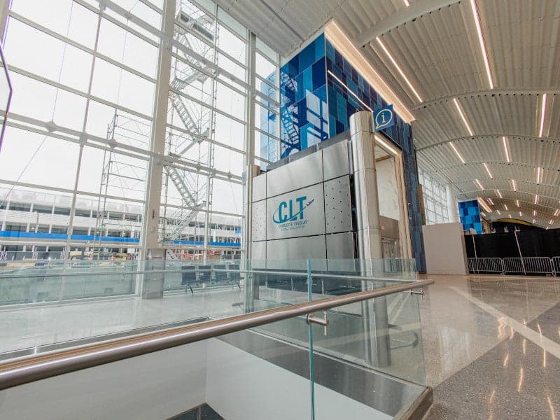 Wide shot of a modern, empty airport terminal lobby with seating areas