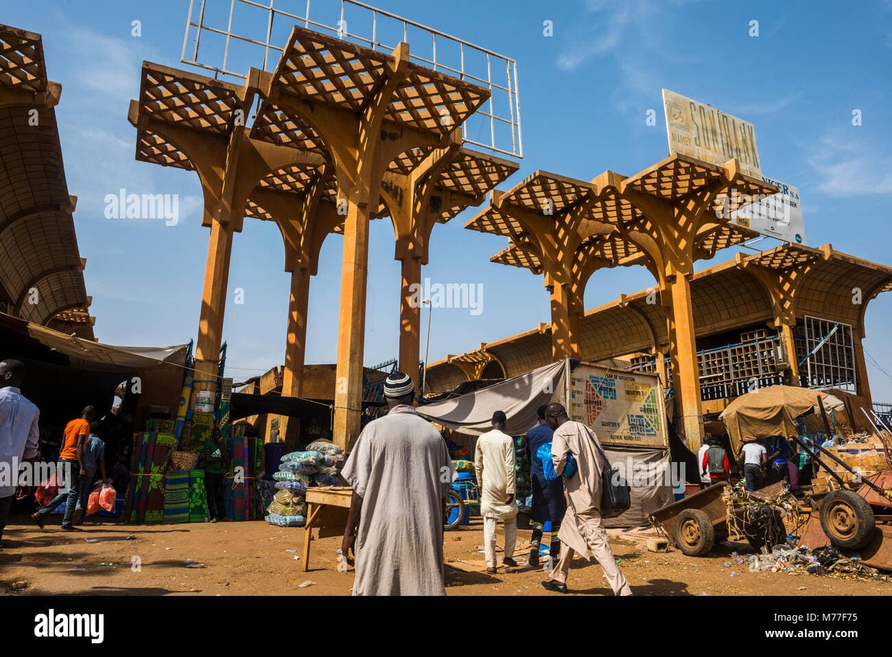 Wide shot of a busy open-air market with stalls and structures in Niamey, Niger
