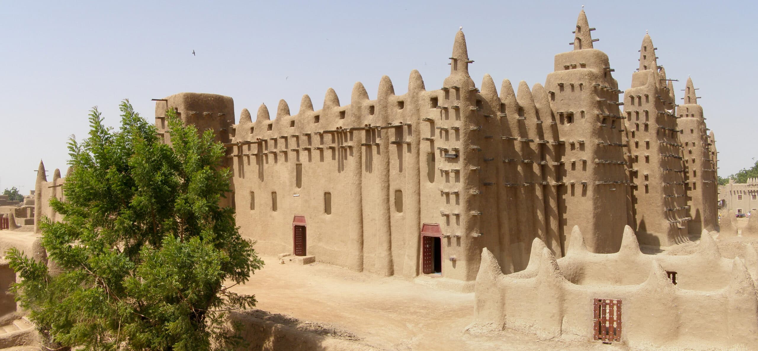Exterior of a traditional earthen building with mud-brick walls and wooden beams