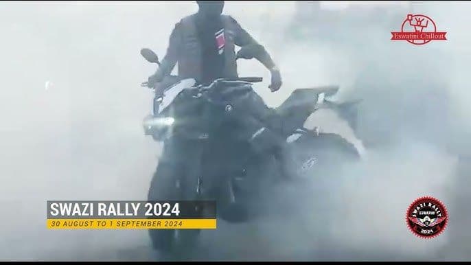 Motorcyclist riding through dust at the Swazi Rally 2024, with event logos and date text overlaid.