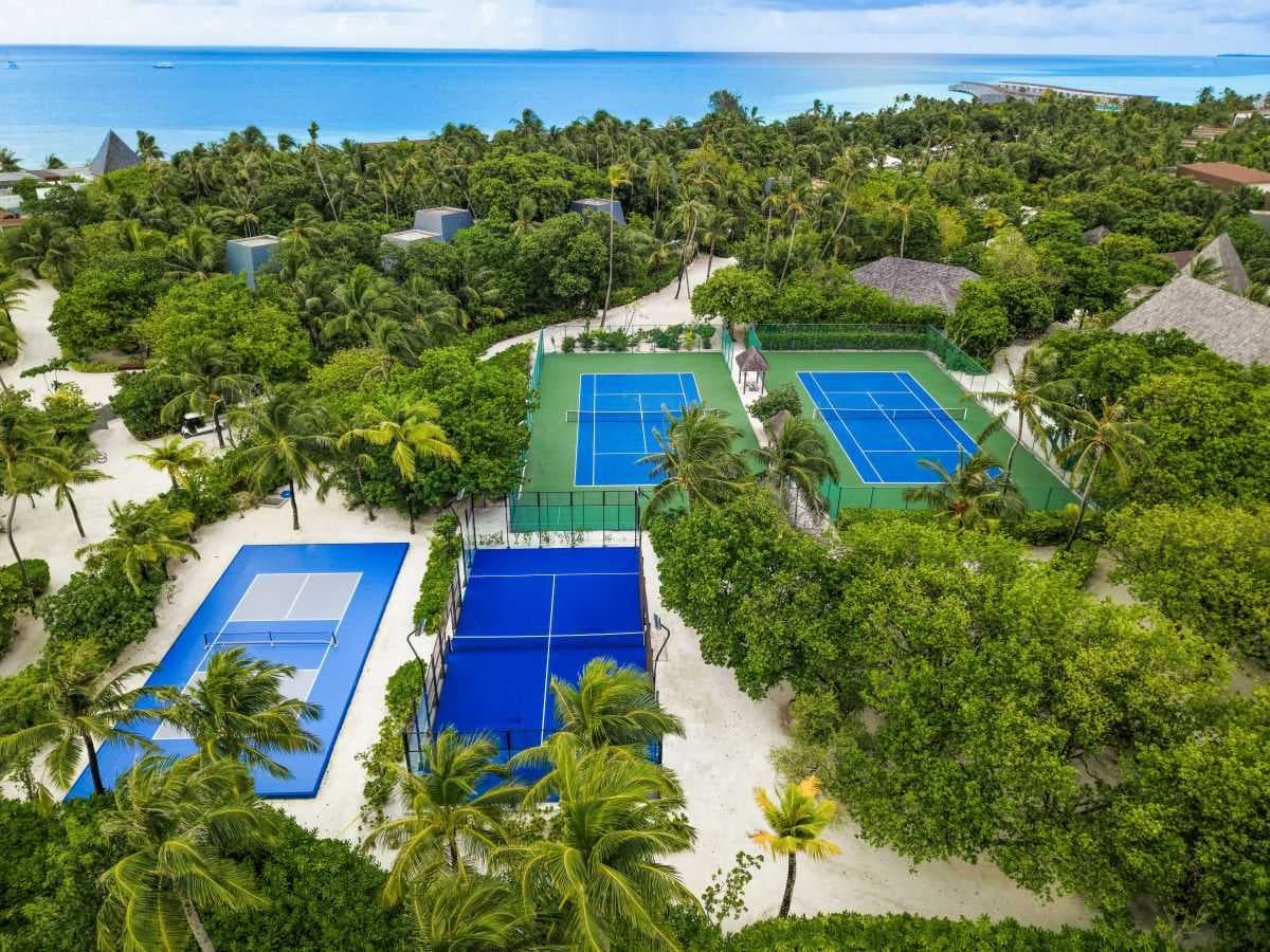 Aerial view of sports facilities surrounded by lush tropical vegetation and palm trees on Viligili.
