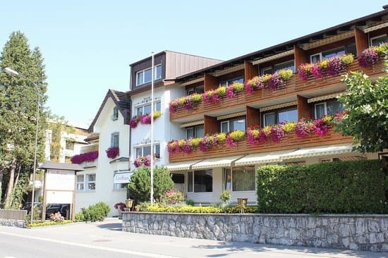 Front facade of Hotel Schaanerhof in Schaan, Liechtenstein showing a traditional chalet-style building surrounded by trees