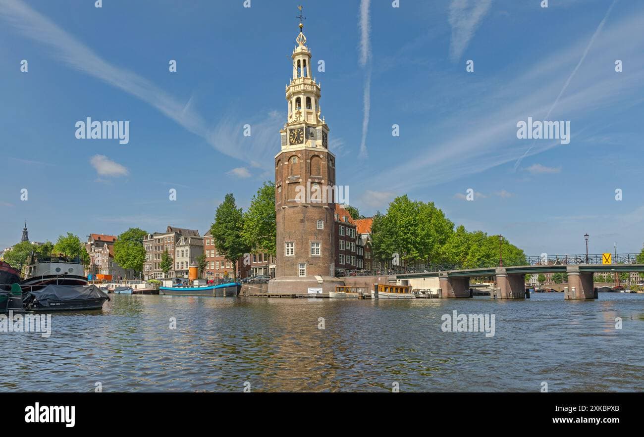 Establishing shot of the historic Montelbaanstoren tower and bridge over the Oudeschans canal in Amsterdam, Netherlands, on a sunny spring day