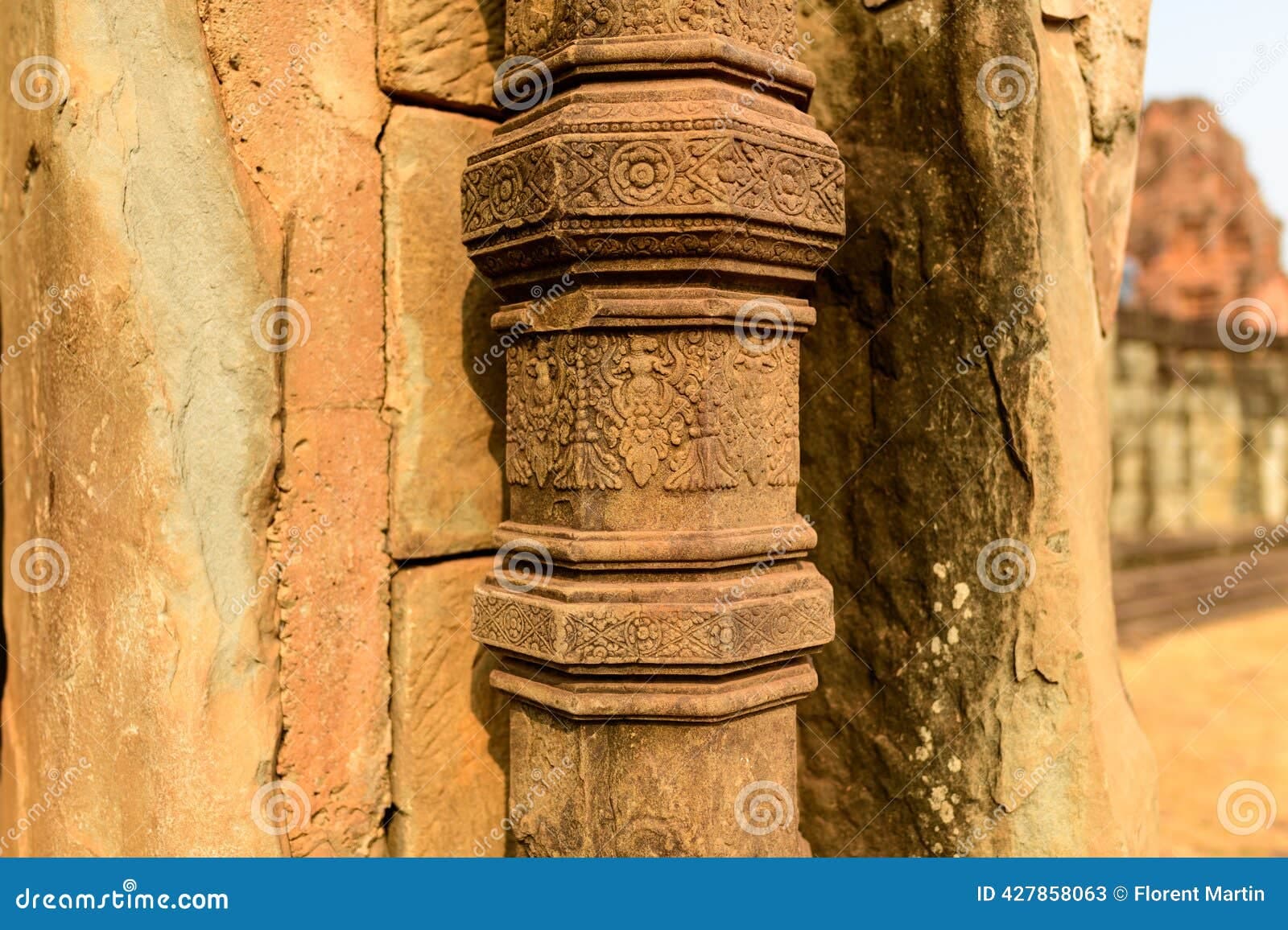 Detailed close-up of a sandstone column with intricate carvings at Prasat Bakong temple in Cambodia