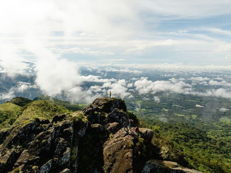 Highland mountain ridge with rocky outcrops and a vast cloud-covered valley below, in the Chiriquí highlands near La Mitra, Panama.