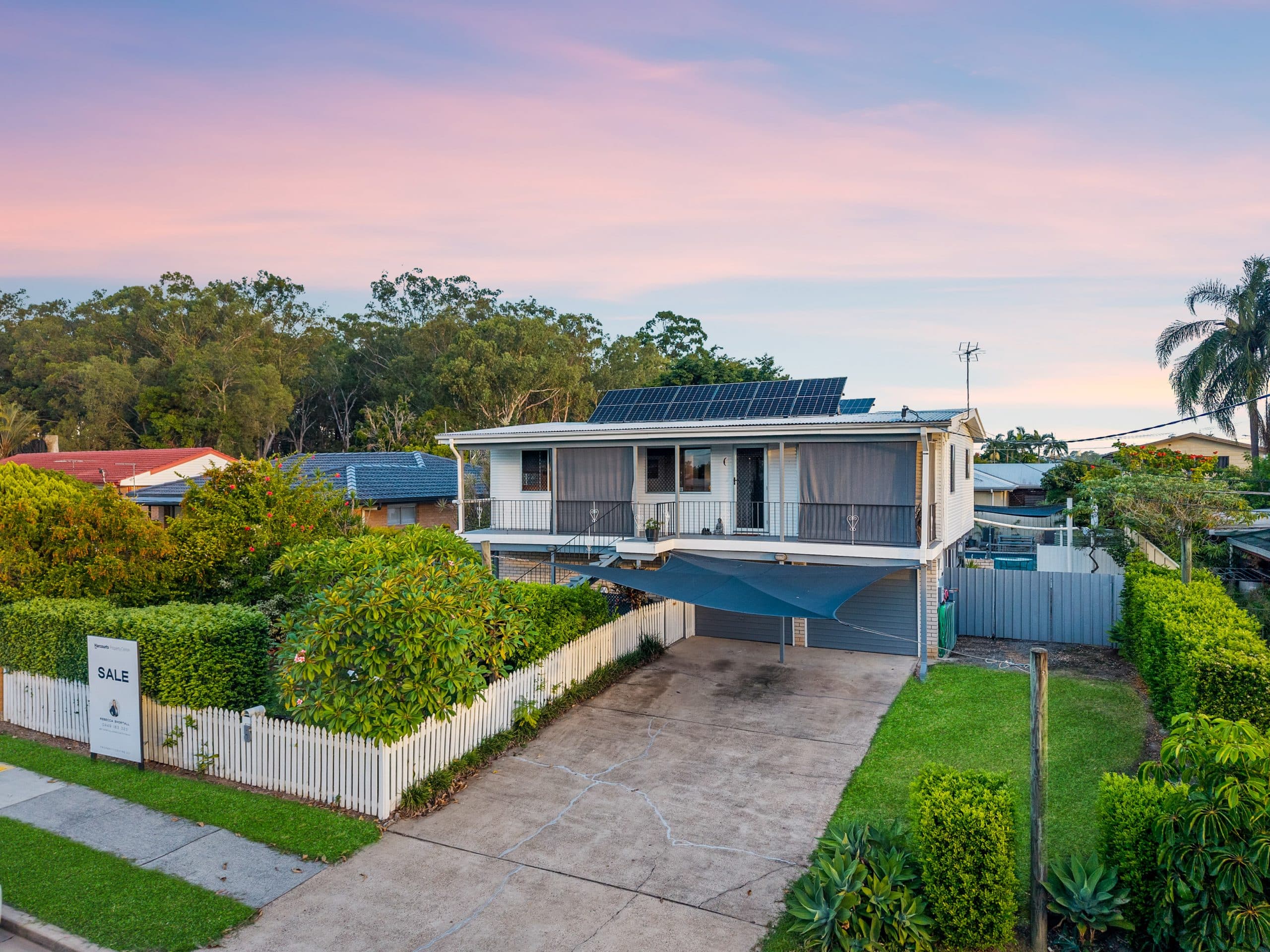 Quiet suburban street with modern houses and green trees in Logan City, Queensland, Australia