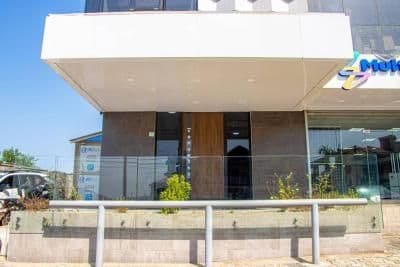 Exterior view of a modern building with a large overhanging roof and glass facade in Port Loko, Sierra Leone.