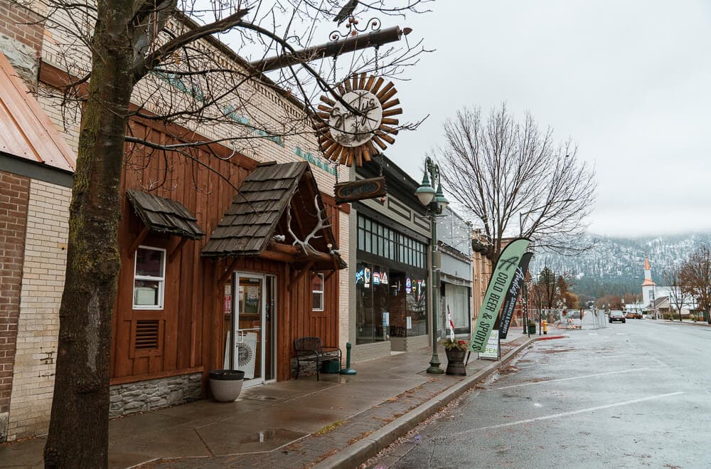Entrance to Sportys restaurant on Main Street in Chewelah, Washington, with historic buildings and spring foliage