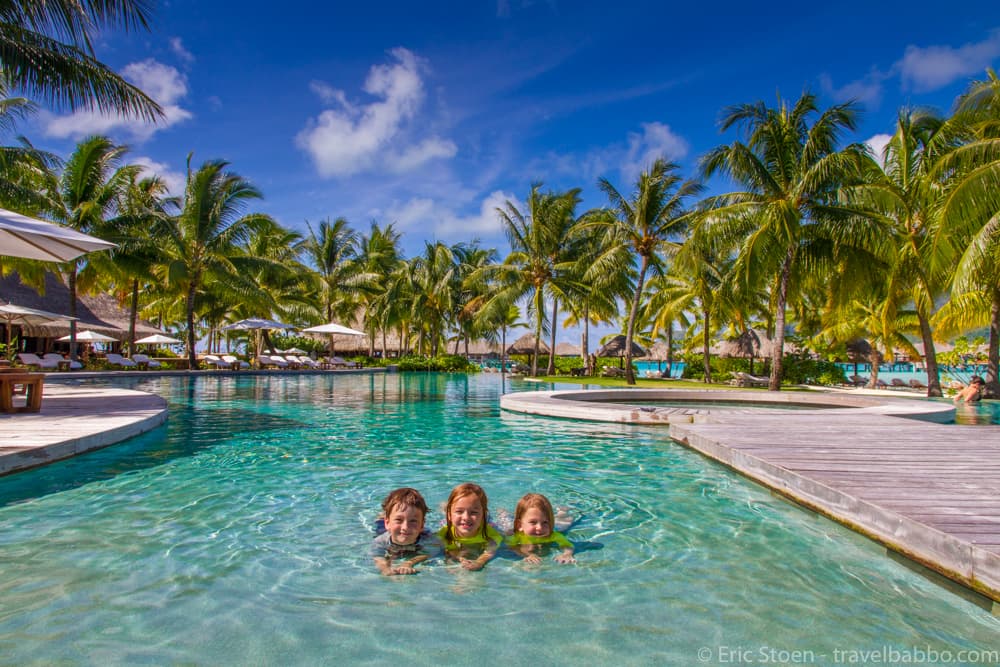 Family enjoying a sunny day by a resort pool in Jakarta during spring