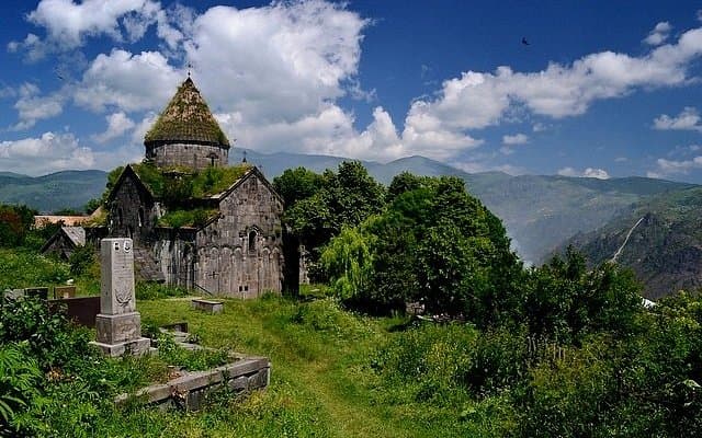 Exterior view of the historic 13th-century Sanahin Monastery surrounded by lush green trees