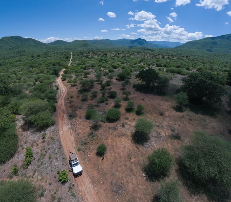 Expansive rural landscape with green fields and hills in southern Tanzania during the dry season