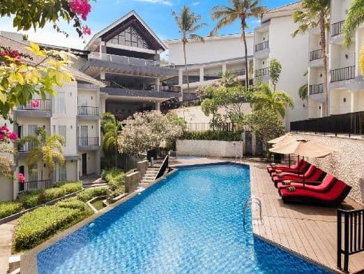 Resort-style lodging complex in Luwuk, Kabupaten Banggai, Indonesia, featuring a swimming pool, lounge chairs, and tropical landscaping under a clear sky