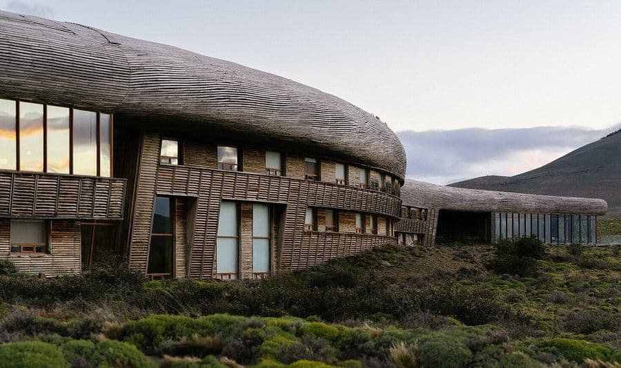 Low rural building with gently sloped wooden roofline in a pampa landscape at dusk.