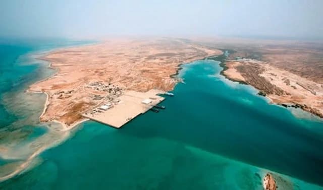 Aerial view of Şabyā's Red Sea coastline with turquoise water, a small settlement, and a pier